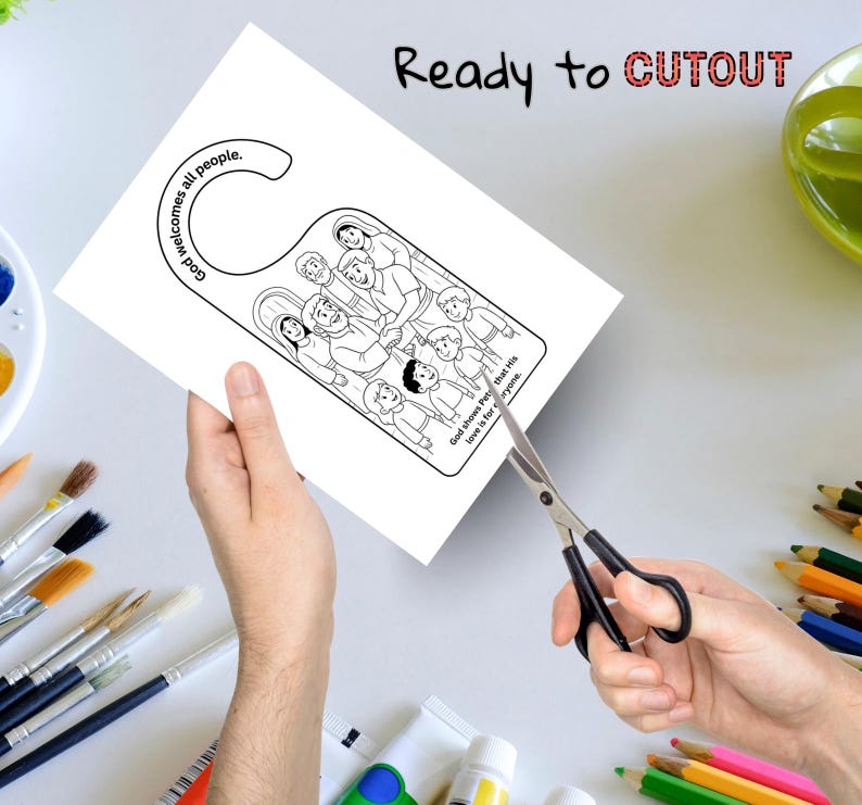 May include: A white paper door hanger with a black and white illustration of people. The text "God welcomes all people" and "God shows that His love is for everyone" are visible. The words "Ready to CUTOUT" are written at the top.