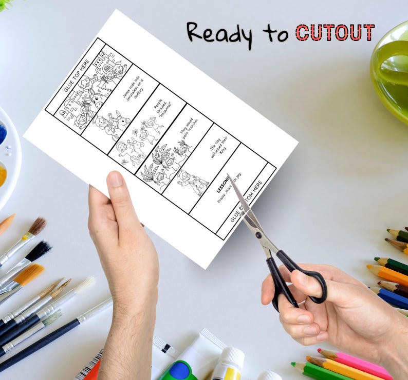 May include: A white paper with a black and white illustrated story is being cut with scissors. The text "Ready to CUTOUT" is written in black and red. The paper has the text "GLUE TOP HERE" and "GLUE BOTTOM HERE".