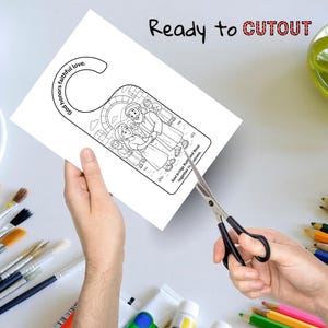 May include: A white door hanger with a black and white illustration of a couple and the text "God honors faithful love." The words "Ready to CUTOUT" are at the top. Scissors are cutting the door hanger.