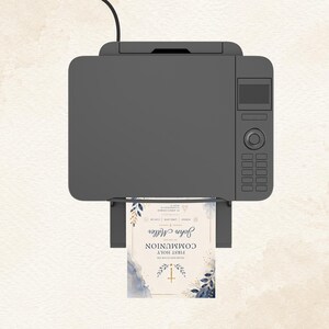 May include: A gray printer printing a First Holy Communion invitation. The invitation features a watercolor design with blue and gold accents, the name "John Miller", and a cross.