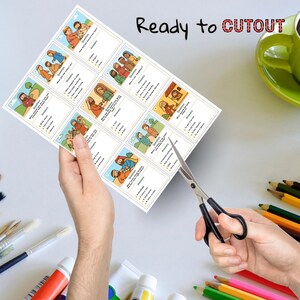May include: A sheet of paper with illustrated Bible story cards is being cut out with scissors. The cards have questions and answers. The words "Ready to CUTOUT" are printed at the top. Paint tubes, paint brushes, and colored pencils are in the background.