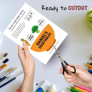 May include: A printable craft activity sheet titled "Daniel's Vegetables" with an orange bowl graphic. The sheet includes text, illustrations of vegetables, and the words "Ready to CUTOUT". Scissors are cutting the sheet.