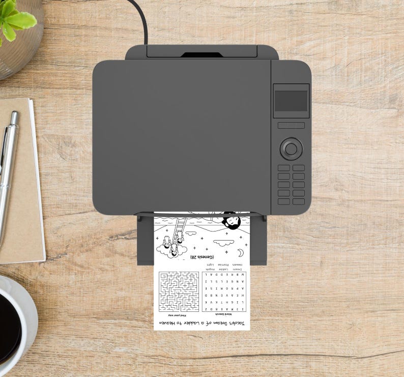 May include: A gray printer is printing a black and white coloring page with the text "Jacob's Dream of a Ladder to Heaven". The page includes a maze, a word search, and illustrations of angels.