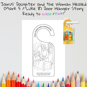 May include: A white door hanger with a black and white illustration of a biblical scene, featuring Jesus healing a woman. The text reads "Jairus' Daughter and the Woman Healed" and "Ready to colour/paint."