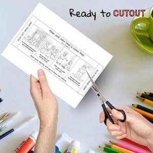 May include: A black and white illustrated comic strip titled "Peter and John Heal a Lame Man" is being cut out with scissors. The text "Ready to CUTOUT" is above the comic. A green mug of coffee and art supplies are in the background.