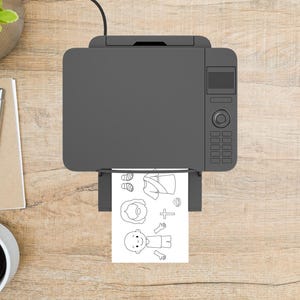 May include: A gray printer printing a black and white coloring page with religious figures and symbols. The page includes images of a person with a beard, a cross, and a person with arms outstretched. The printer is on a wooden surface.