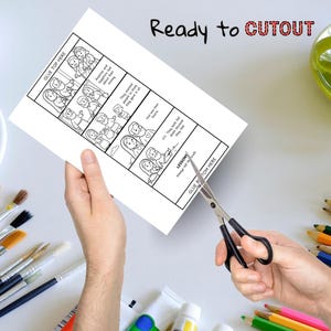 May include: A black and white comic strip with the text "Ready to CUTOUT" is being cut with scissors. The comic strip depicts a story with text bubbles and the words "GLUE TOP HERE" and "GLUE BOTTOM HERE".