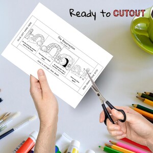 May include: A black and white illustrated paper with the text "The Resurrection" and "Ready to CUTOUT" is being cut with scissors. The paper depicts a biblical scene with text from Luke Chapter 24.