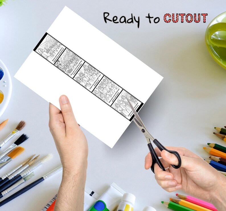 May include: A white sheet of paper with a black and white illustrated strip is being cut with scissors. The strip contains several panels with drawings of people. The text "Ready to CUTOUT" is written at the top of the paper.