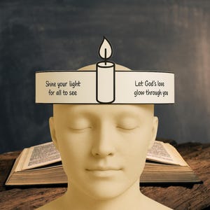 Puede incluir: Una diadema blanca con una ilustraci&oacute;n de vela negra y el texto "Shine your light for all to see" en el lado izquierdo y "Let God's love glow through you" en el lado derecho.