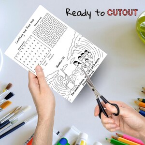 May include: A black and white activity sheet with the text "Crossing the Red Sea" and a word search puzzle. The sheet also features a maze and an illustration of people crossing the sea. Scissors are cutting the sheet.