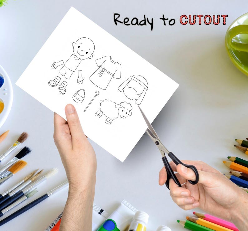 May include: A white paper with black line drawings of a cartoon figure, clothing, a sheep, and accessories. The text "Ready to CUTOUT" is written in black and red. Scissors are cutting the paper.