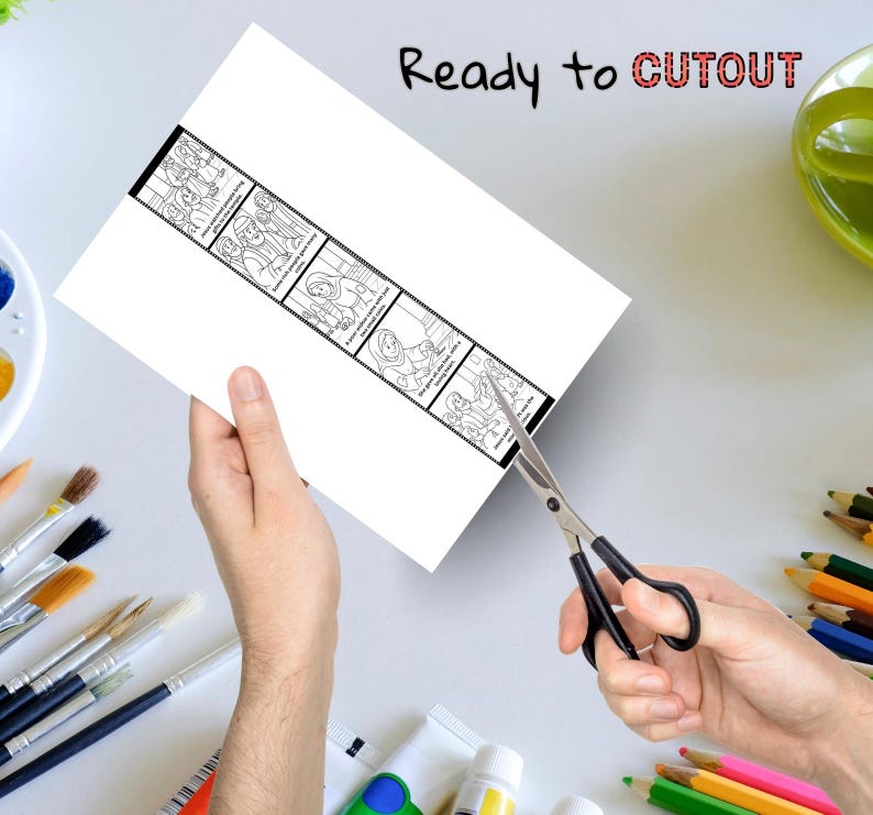 May include: A white sheet of paper with a black and white illustrated strip is being cut with scissors. The strip contains several panels with drawings and text. The words "Ready to CUTOUT" are written at the top in black and red.