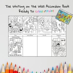 Peut inclure: Livre accordéon en noir et blanc intitulé "The Writing on the Wall", prêt à être colorié ou peint. Le livre présente des illustrations de scènes bibliques, dont le festin du roi Balthazar et l'interprétation de Daniel. Un exemple de livre est montré.