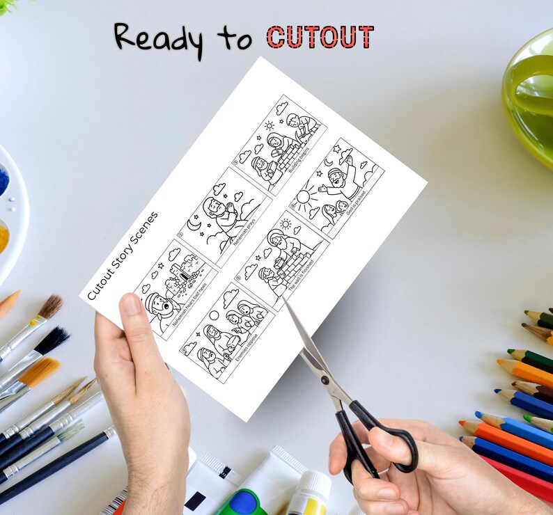 May include: A white sheet with black line drawings of cutout story scenes is being cut with scissors. The text "Ready to CUTOUT" is at the top, and "Cutout Story Scenes" is on the left side of the sheet.