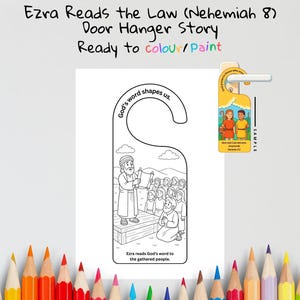 May include: A white door hanger with a black and white illustration of Ezra reading to a crowd. The text "Ezra Reads the Law (Nehemiah 8) Door Hanger Story Ready to colour/Paint" is at the top. The text "God's word shapes us" is also present.