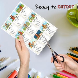 May include: A sheet of paper with illustrated cards featuring biblical scenes, held by hands with scissors cutting the cards. The text "Ready to CUTOUT" is printed at the top. A green mug and coloured pencils are in the background.