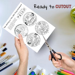 May include: A black and white printable ornament sheet with illustrations and text. The sheet includes instructions and the words "Ready to CUTOUT". A pair of scissors is cutting the sheet.