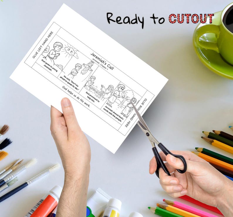 May include: A person is cutting out a black and white illustrated coloring page with scissors. The page is titled "Jeremiah's Call" and features biblical scenes and text. The words "Ready to Cutout" are written at the top of the page.