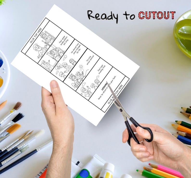 May include: A sheet of white paper with a black and white illustrated story, being cut with scissors. The text "Ready to CUTOUT" is above the paper. The paper has the text "GLUE TOP HERE" and "GLUE BOTTOM HERE".