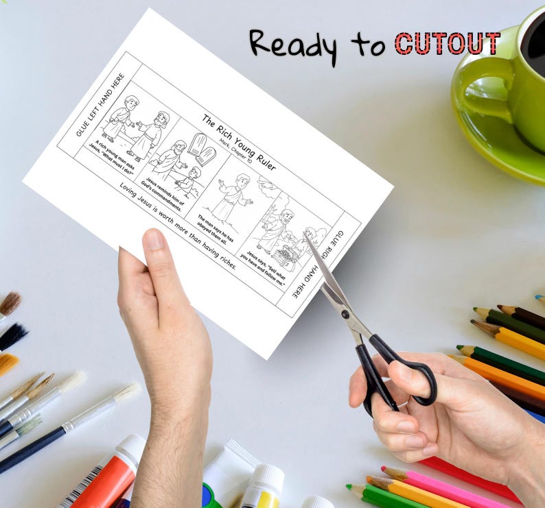 May include: A black and white illustrated activity sheet titled "The Rich Young Ruler" with the text "Ready to CUTOUT". The sheet is being cut with scissors. A green mug and colored pencils are in the background.