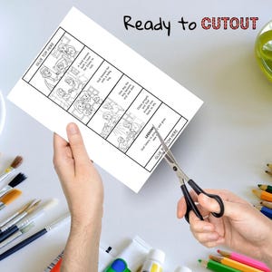 May include: A black and white illustrated cutout sheet with text, held by hands, being cut with scissors. The text includes "Ready to CUTOUT" and instructions like "GLUE TOP HERE" and "GLUE BOTTOM HERE". The sheet depicts a story in panels.