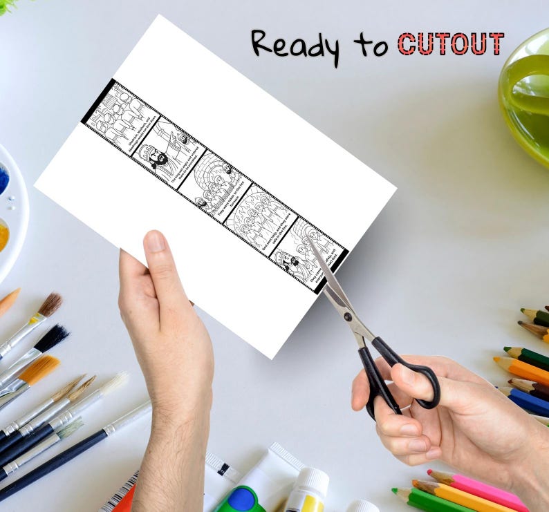 May include: A white sheet of paper with a black and white illustrated strip is being cut with scissors. The strip contains several panels with drawings and text. The words "Ready to CUTOUT" are written at the top.