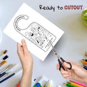 May include: A black and white door hanger with a biblical illustration of a man helping another. The text "Love others with compassion" and "A Samaritan lovingly helps a man in need" are visible. The words "Ready to CUTOUT" are also present.
