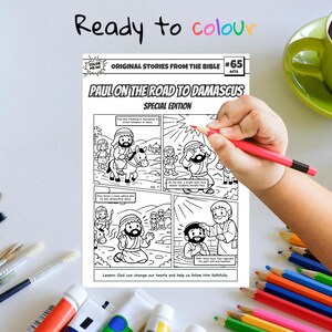 May include: A black and white coloring book page titled "Paul on the Road to Damascus" with comic-style illustrations. The text "Ready to colour" is written at the top. A hand is holding a red pencil, ready to color the page.