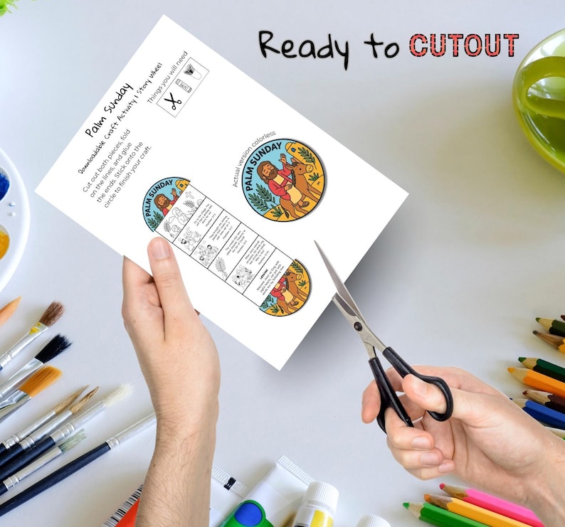 May include: A white paper with the text "Palm Sunday" and illustrations is being cut with scissors. The paper includes instructions and a circular image. The words "Ready to CUTOUT" are at the top.