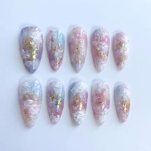 Puede incluir: Una taza de cerámica blanca con un asa negra y el texto "But First, Coffee" en negro, con una fuente de estilo manuscrito. La taza está sobre una superficie blanca.