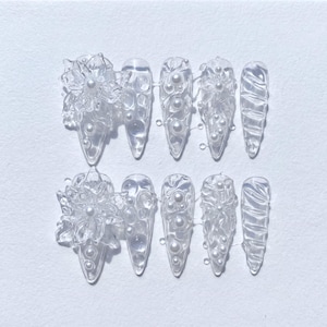 May include: A set of three ceramic mugs with a speckled, matte finish. The mugs are in shades of cream, light gray, and dark gray. Each mug has a simple, minimalist design and a rounded handle.