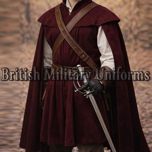 Puede incluir: Un uniforme militar de color burdeos con una capa a juego y correas de cuero. El uniforme incluye una espada y el texto "British Military Uniforms". El atuendo recuerda la vestimenta militar histórica.