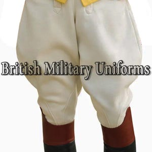 Puede incluir: Pantalones militares color crema con cintura alta y forma redondeada. Los pantalones se combinan con botas de cuero marrón. El texto "British Military Uniforms" se muestra en la parte inferior de la imagen.