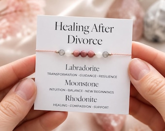 May include: A bracelet featuring pink beads and a card with the text "Healing After Divorce." The card details Labradorite, Moonstone, and Rhodonite, with related keywords. The bracelet is set against a soft, blurred backdrop.