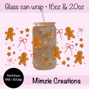 May include: A glass can wrap with a wooden lid and a straw. The wrap features a gingerbread man design with stars and pink bows. The text "Glass can wrap - 16oz & 20oz" is at the top. The bottom of the image says "Mimzie Creations".