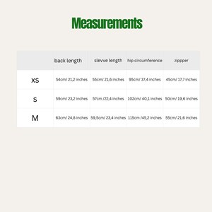 May include: A chart with the word "Measurements" in green text at the top. The chart shows back length, sleeve length, hip circumference, and zipper measurements in both centimeters and inches for sizes XS, S, and M.