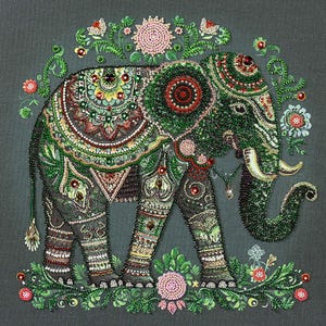 Può includere: Un elefante perlato con accenti verdi, rossi e dorati, circondato da decorazioni floreali. L'elefante è in piedi su uno sfondo verde.