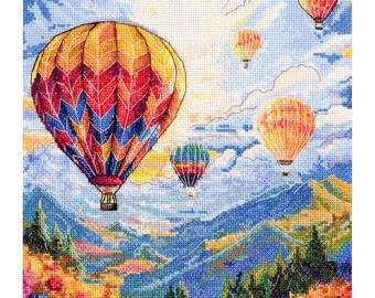 Könnte beinhalten: Ein Kreuzstichbild von Heißluftballons, die über einer Berglandschaft schweben. Der größte Ballon ist gelb, rot und blau. Andere Ballons sind orange und rot. Die Szene umfasst grüne Bäume und bunte Blumen.
