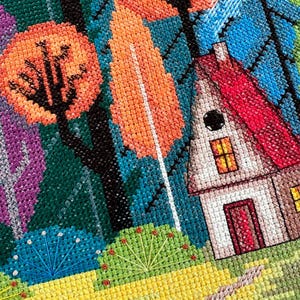 May include: A cross-stitch embroidery depicting a colorful forest scene with a small house in the foreground. The house has a red roof, white walls, and a black door. The forest is filled with trees in shades of green, blue, orange, and purple. The ground is a bright yellow with a path leading to the house.