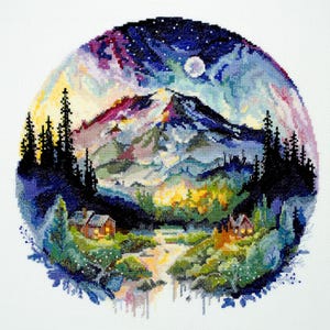 May include: A cross-stitch embroidery depicting a night scene with a mountain range, two small houses, and a full moon in a starry sky. The colours are vibrant and include shades of blue, purple, pink, yellow, and green.