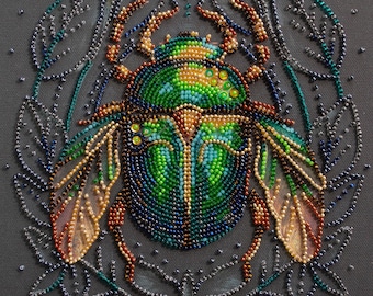 Könnte beinhalten: Ein grüner und blauer, mit Juwelen besetzter Käfer mit Flügeln, umgeben von einem perlenbesetzten Blumendesign.