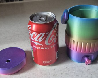 Könnte beinhalten: Eine rote Coca-Cola-Dose neben einem lila-blauen Ombre-Deckel und einem passenden Ombre-Getränkehalter. Der Getränkehalter hat einen Wasserhahn und Griffe. Auf der Dose steht "Coca-Cola Original Taste Delicious & Refreshing."