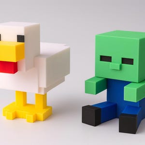 K&ouml;nnte beinhalten: Zwei blockartige Figuren: ein wei&szlig;es Huhn mit gelben und roten Akzenten und ein Zombie mit gr&uuml;nem Kopf und blauem K&ouml;rper. Das Huhn steht, der Zombie sitzt. Die Figuren sind im Stil eines beliebten Videospiels gehalten.