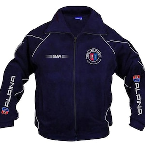 Puede incluir: Una chaqueta azul marino con cremallera, ribetes blancos y las palabras "ALPINA" y "BMW" en las mangas y "ALPINA" en el pecho.