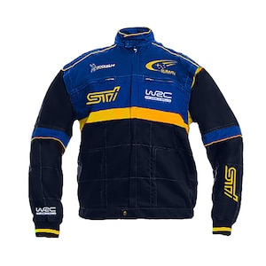 Puede incluir: Chaqueta de carreras azul marino y amarilla con los logotipos de Subaru y STI. La chaqueta tiene un diseño acolchado, cuello alzado y el texto "WRC" en las mangas. La chaqueta es de peso medio y tiene cierre de botón.