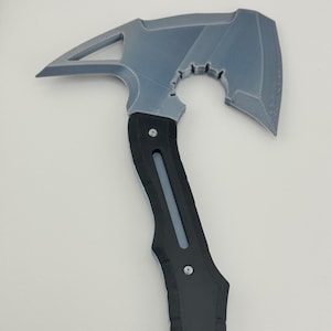 May include: A gray and black axe with a unique design. The axe head is gray with a triangular opening and a curved edge. The handle is black with gray accents and rivets.
