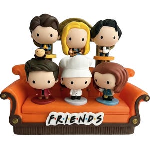 Pu&ograve; includere: Un set di statuette raffiguranti sei personaggi dei cartoni animati della serie TV "Friends" su un divano arancione. Il divano ha la scritta "FRIENDS" sul davanti. Ogni personaggio ha una posa, un'acconciatura e un abbigliamento unici.