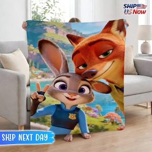 May include: A plush blanket featuring Judy Hopps and Nick Wilde from Zootopia. Judy, a gray rabbit, flashes a peace sign, while Nick, an orange fox, smiles. The background depicts a vibrant cityscape.