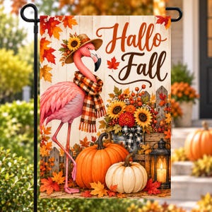 May include: A rectangular garden flag featuring a pink flamingo wearing a sunflower-adorned hat and a plaid scarf. The text Hallo Fall is printed in brown script. The scene includes orange and white pumpkins, sunflowers, and autumn leaves.